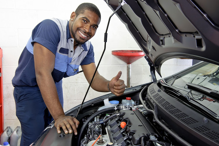 man next to car in garage